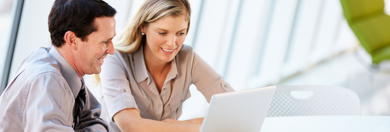 two people focused on a laptop screen, engaged in a shared activity.