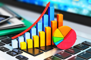 a colourful pie chart and graph placed on top of a laptop, representing data analysis.