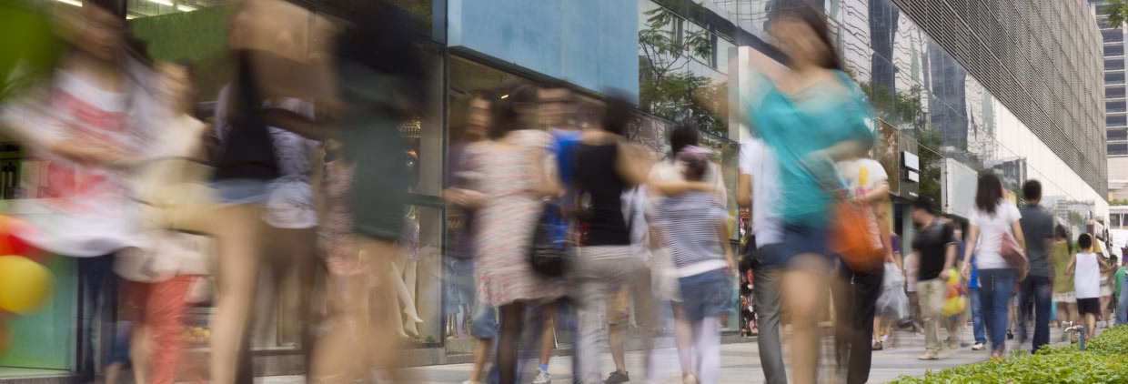 people walking along a busy high street, blurred in motion